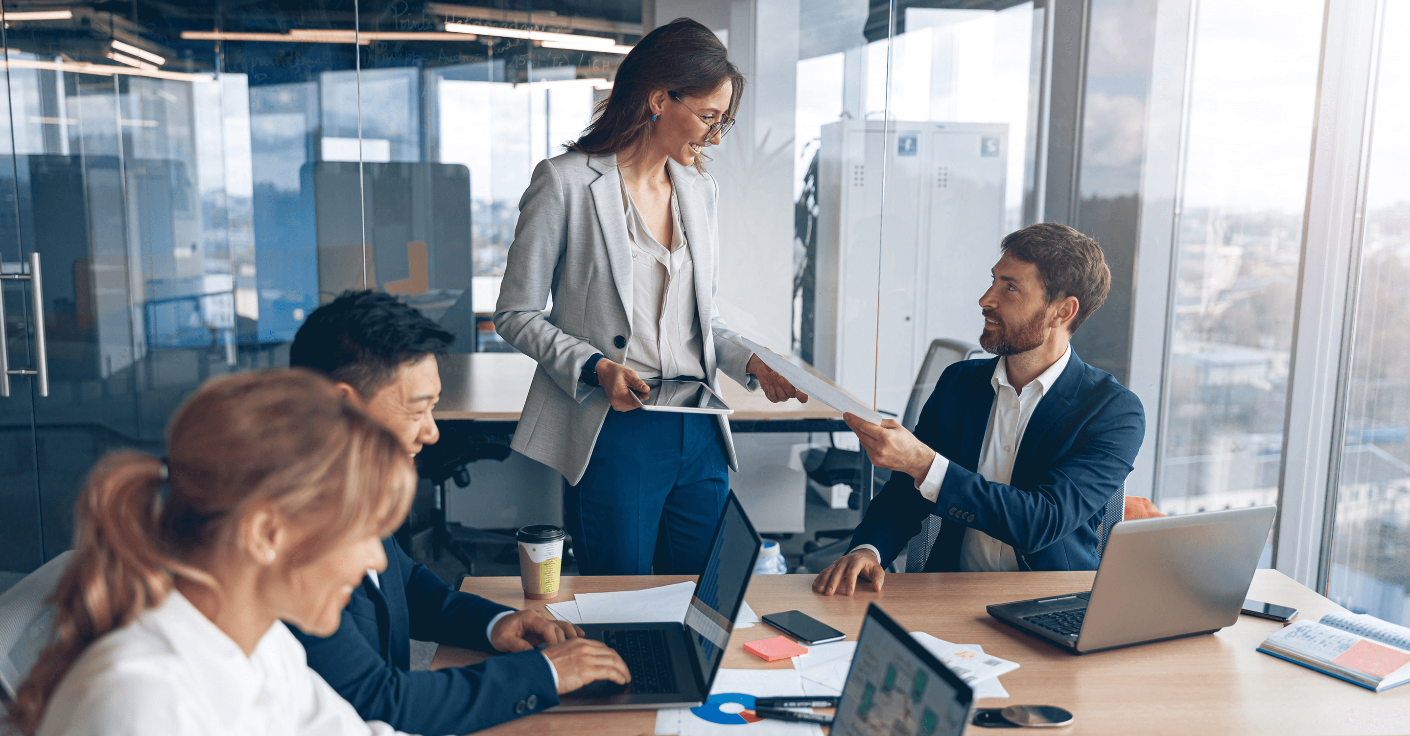 A professional woman and man reviewing documents in a modern office.