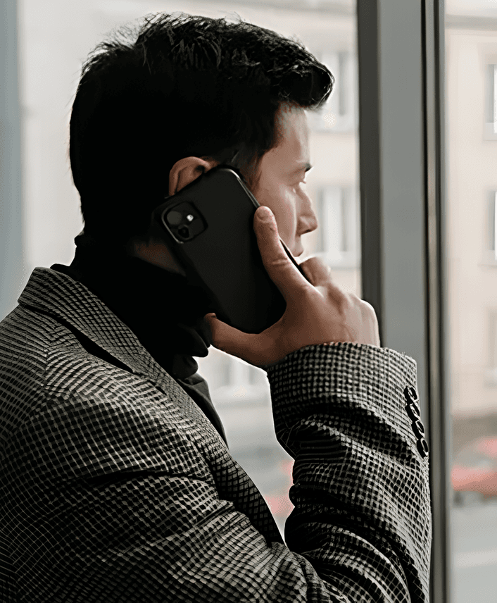 A man in a professional setting talking on the phone